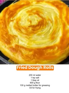 Golden fried dough rolls served with a dusting of powdered sugar.