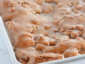 Deliciously moist Apple Dapple Cake with apples and nuts on a wooden table