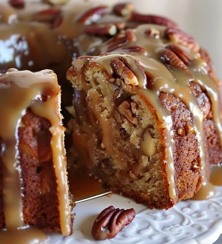Delicious apple pecan cake drizzled with caramel glaze on a rustic table