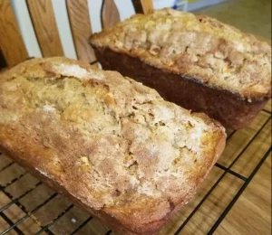 Deliciously baked apple pie bread with slices adorned with cinnamon and apples.