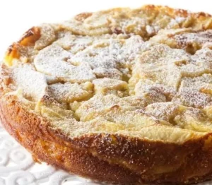 Slice of classic French apple cake with apples and a dusting of powdered sugar