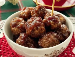 Cranberry glazed veal meatballs served on a plate with a garnish