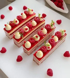 Creamy raspberry cheesecake slice with fresh raspberries on top