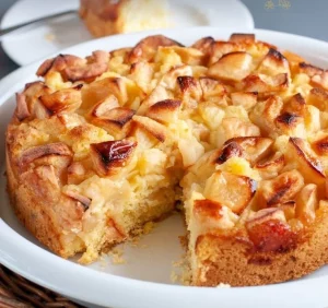 Slice of Italian Apple Cake topped with powdered sugar on a wooden table