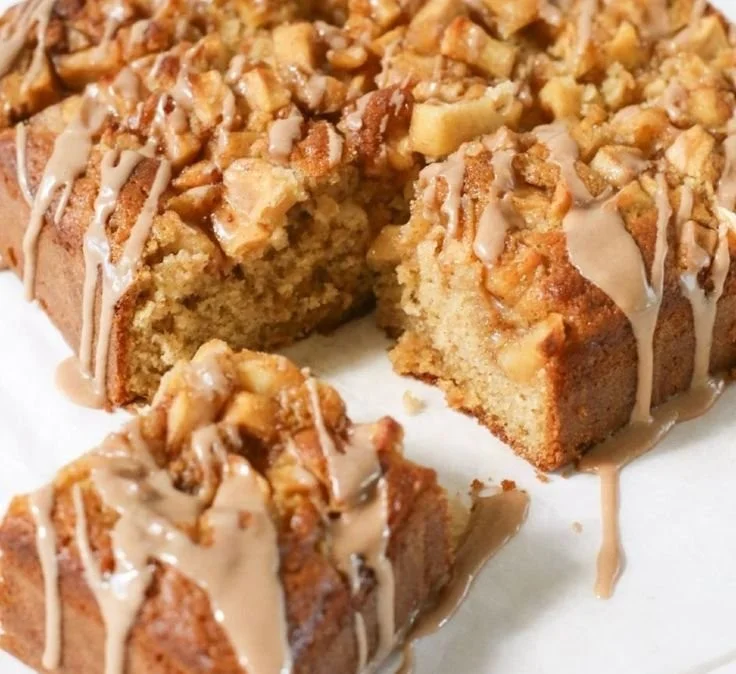 Spiced apple coffee cake with cinnamon and fresh apples on a wooden table.