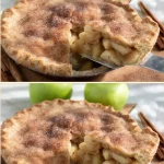 Homemade apple pie with golden crust and sliced apples on a wooden table.