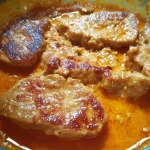 Plate of delicious peasant cutlets served with vegetables and herbs.