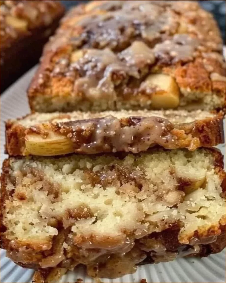 Sliced cinnamon swirl apple fritter bread on a wooden board