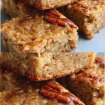 Freshly baked banana oatmeal bars on a wooden table, healthy snack option.