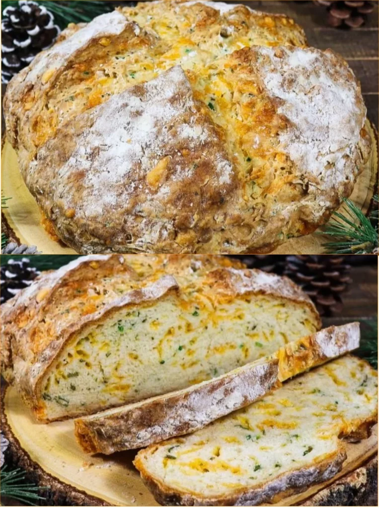 Freshly baked Cheddar and Herb Soda Bread sliced on a wooden cutting board.