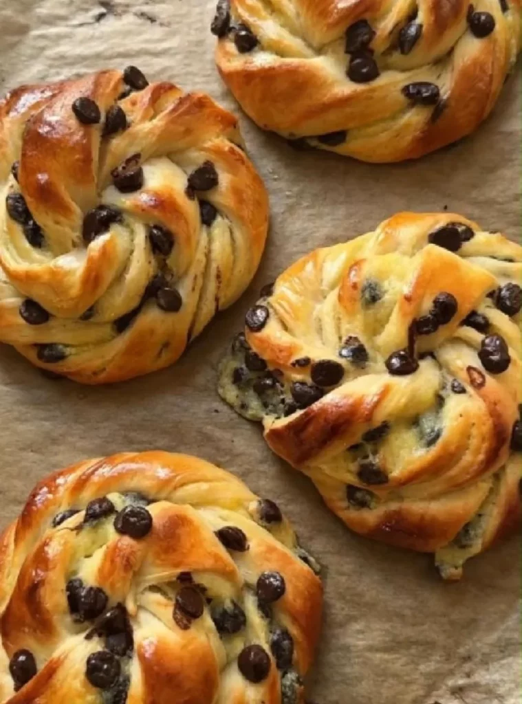 Vanilla cream brioche swirled with chocolate chips on a wooden surface.